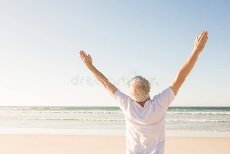 Rear View of Senior Man with Arms Raised Standing at Beach Stock Photo ...