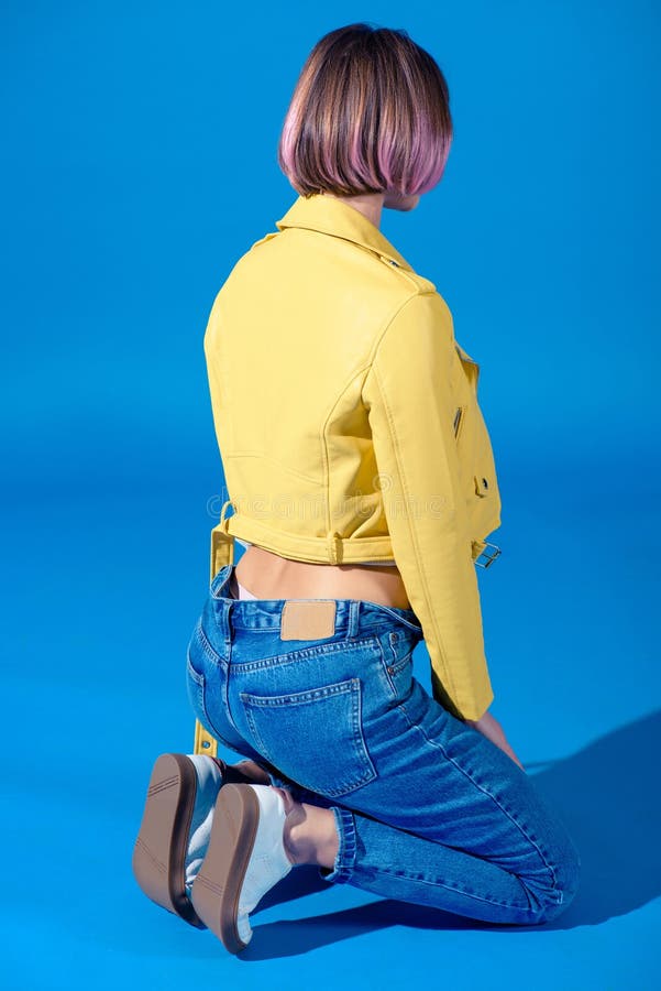 Rear View of Stylish Girl Sitting on Knees in Jacket and Jeans Stock ...