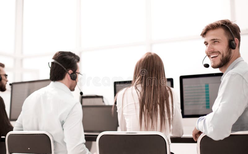 Rear view. young customer service agent sitting at his Desk royalty free stock photos Rear view. young customer service agent sitting at his Desk royalty free stock photos