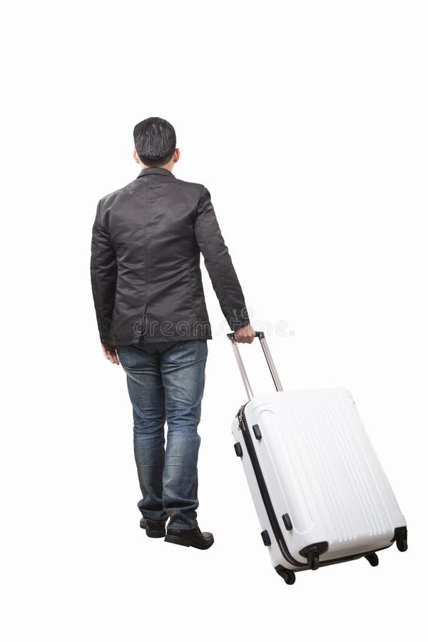 Rear view of young man and pulling belonging luggage walking to