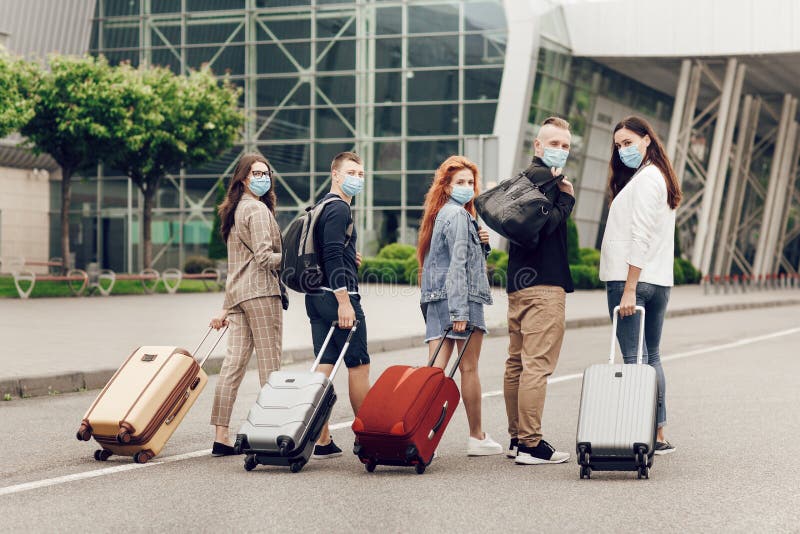 Rear view, young students in protective masks with suitcases go to study abroad after quarantine of coronavirus. royalty free stock photography Rear view, young students in protective masks with suitcases go to study abroad after quarantine of coronavirus. royalty free stock photography