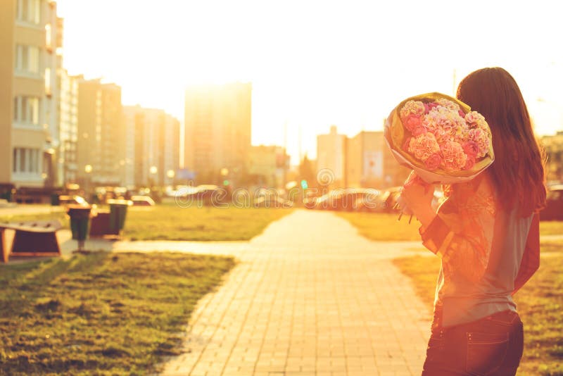 Rear view of young woman receiving a beautiful bouquet of pink p royalty free stock photo Rear view of young woman receiving a beautiful bouquet of pink p royalty free stock photo