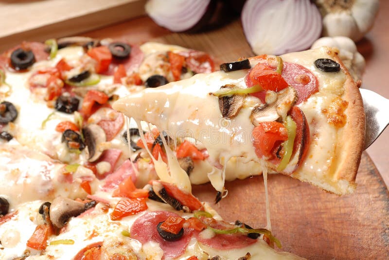 Rebanada caliente de la pizza con queso de fusi?n en una tabla de madera r?stica fotografía de archivo Rebanada caliente de la pizza con queso de fusi?n en una tabla de madera r?stica fotografía de archivo