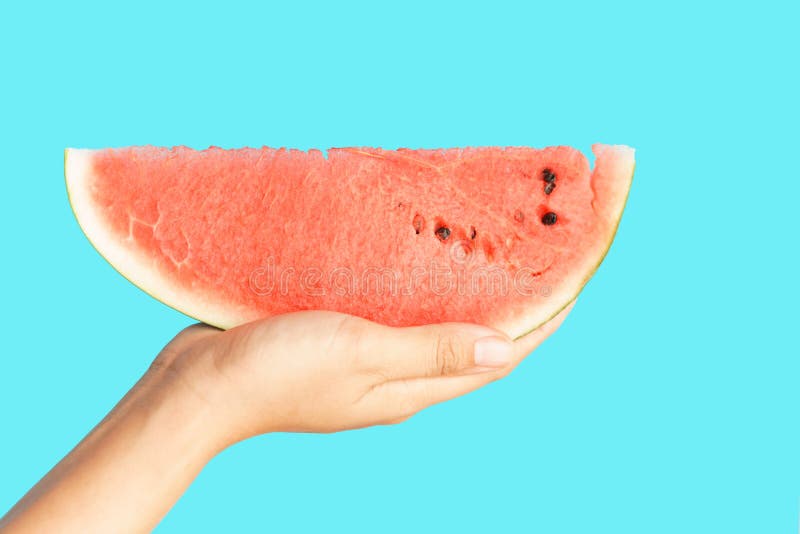 Rebanada de la sandía de la tenencia de la mano en concepto azul del fondo Fruta sana de la sandía para la comida del verano y de imagen de archivo libre de regalías Rebanada de la sandía de la tenencia de la mano en concepto azul del fondo Fruta sana de la sandía para la comida del verano y de imagen de archivo libre de regalías