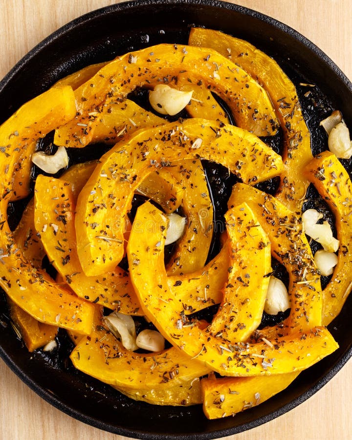Rebanadas de calabaza cocidas con ajo e hierbas imagenes de archivo Rebanadas de calabaza cocidas con ajo e hierbas imagenes de archivo