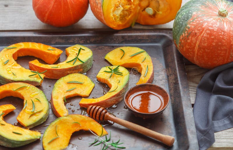 Rebanadas de la calabaza para cocer con romero y miel imágenes de archivo libres de regalías Rebanadas de la calabaza para cocer con romero y miel imágenes de archivo libres de regalías
