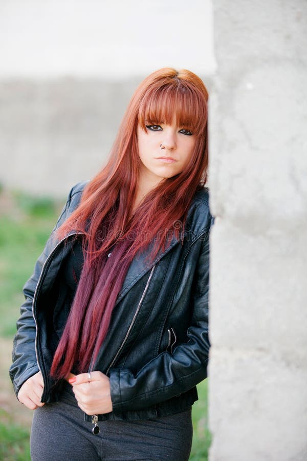 Rebellious Teenager Girl With Red Hair Leaning On A Wall Stock Image