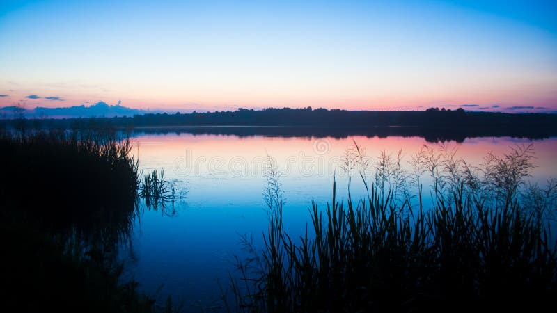 Recente, stille en vreedzame de zomeravond op een grote plattelandsvijver stock foto's Recente, stille en vreedzame de zomeravond op een grote plattelandsvijver stock foto's