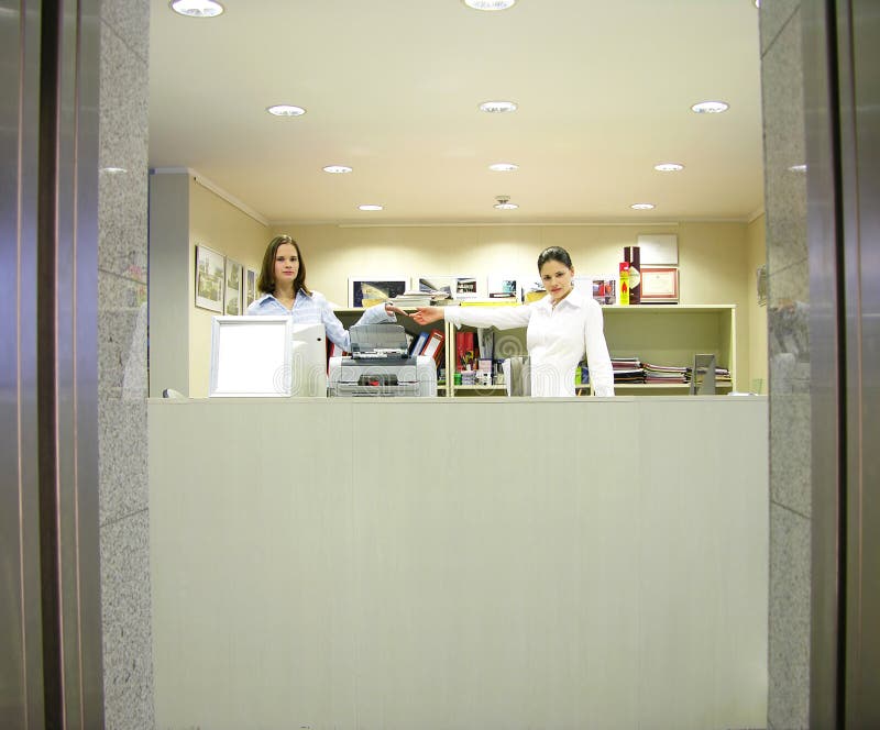 Reception girls - welcome. Girls at reception desk, welcome stock photography Reception girls - welcome. Girls at reception desk, welcome stock photography