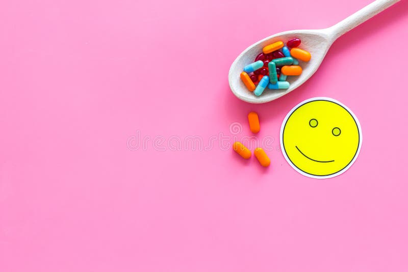 Reception of medicines concept. Recovery. Pills in spoon near smile face emoji on pink background top view copy space stock images Reception of medicines concept. Recovery. Pills in spoon near smile face emoji on pink background top view copy space stock images