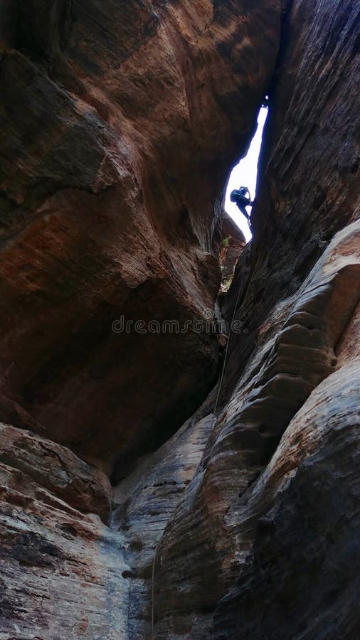 Lambs Knoll is a popular spot for commercial canyoneering. This is a ground view of someone repelling down a slot canyon. Lambs Knoll is a popular spot for commercial canyoneering. This is a ground view of someone repelling down a slot canyon.