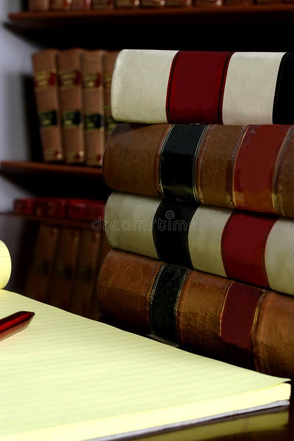 Law books and note pad being used for research. Law books and note pad being used for research.