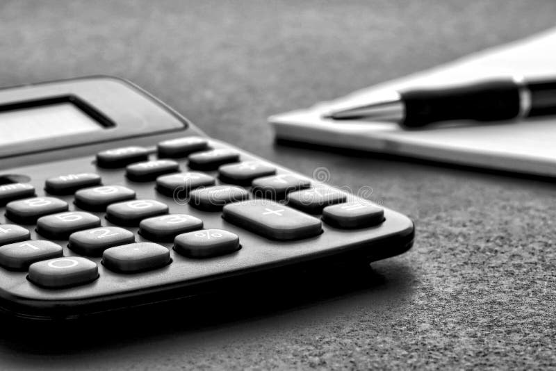 Rechner und Tintenfeder auf Papier Notizblock lizenzfreie stockbilder