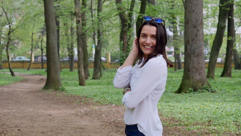 Recht junge Frau genießt Stadt-Park, lächelt