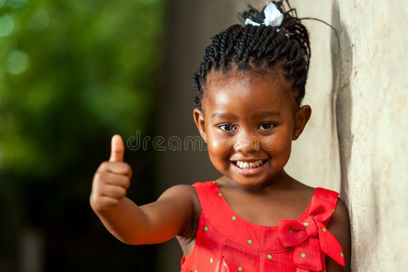 Recht kleines afrikanisches Mädchen, das sich Daumen zeigt. lizenzfreies stockfoto