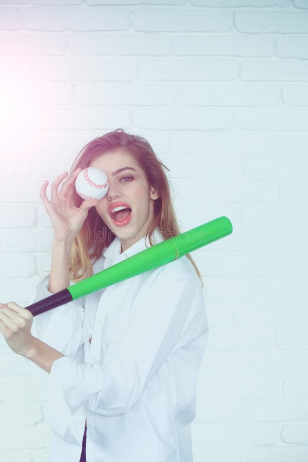 Recht sexy Frau mit dem langen Haar hält grünen Baseballschläger