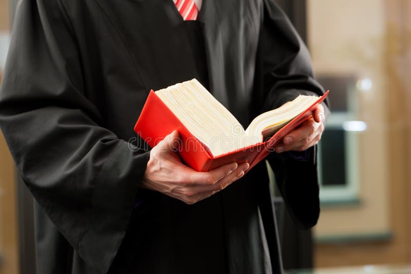 German Lawyer with civil law code in a court room, close-up, only torso to be seen. German Lawyer with civil law code in a court room, close-up, only torso to be seen