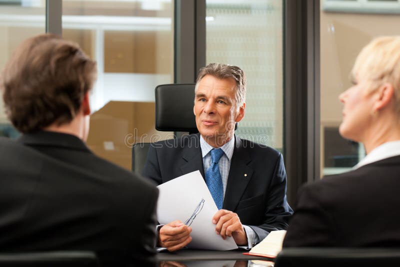 Rechtsanwalt oder Notar mit Klienten in seinem Büro