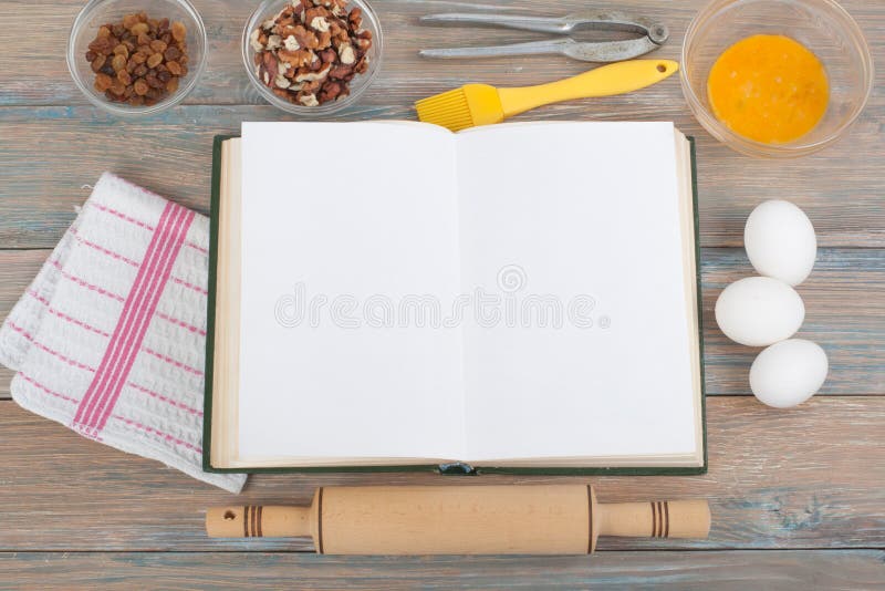 Recipe cook blank book on wooden background, spoon, rolling pin, checkered tablecloth