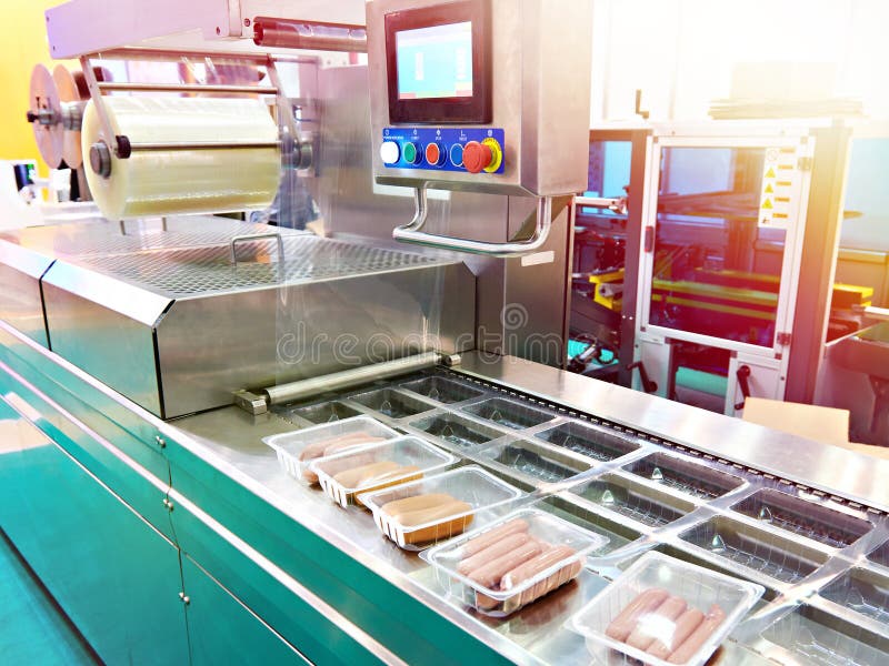 Conveyor at food factory for packing plastic containers with sausages. Conveyor at food factory for packing plastic containers with sausages