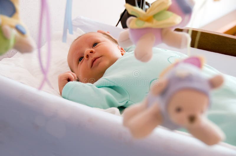 Four week baby smiling and looking at toy carrousel. Four week baby smiling and looking at toy carrousel