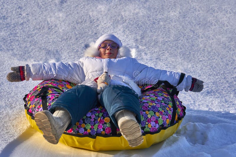 Reconstrucción Una muchacha del niño está descansando después de que un funcionamiento del trineo largo Ella miente en la tubería del trineo Día escarchado del invierno soleado