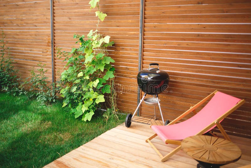 Recreation area in the yard of the house: chairs, barbecue, table