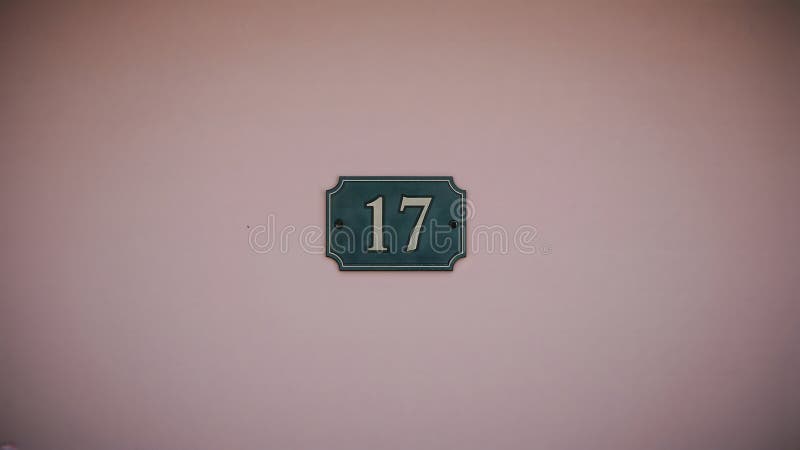 Weathered House Number \'17\' Sign on Pastel Pink Wall vector illustration