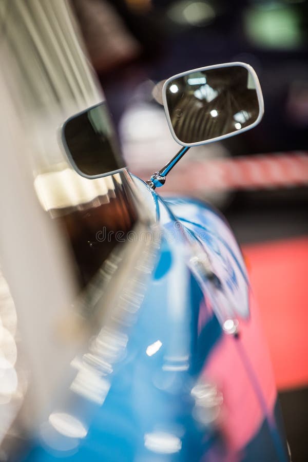 Close up shot of a rectangular rear view mirror on a vintage car