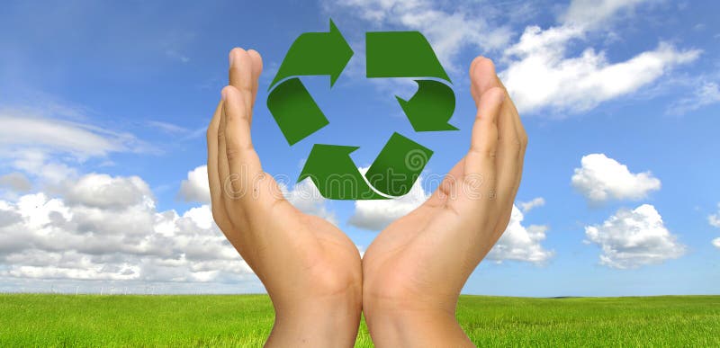 Mani con riciclare simbolo su un campo verde.