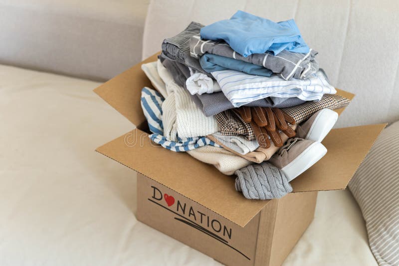 Recycling Concept. a Box Sits on the Sofa Full of Clothes for Donation