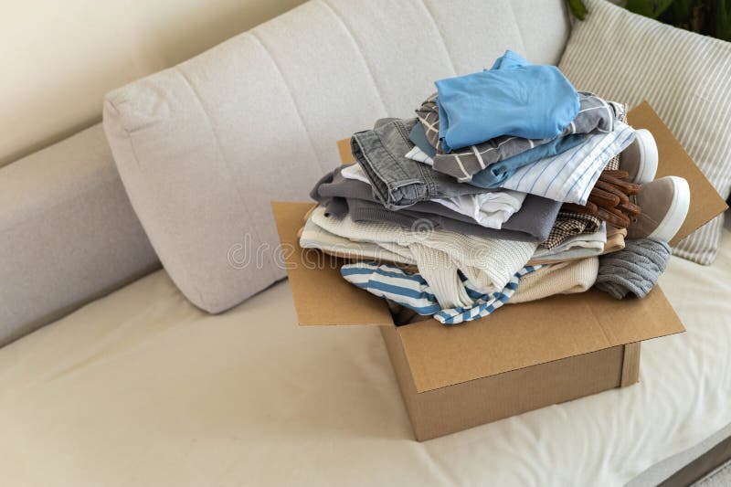 Recycling Concept. a Box Sits on the Sofa Full of Clothes for Donation