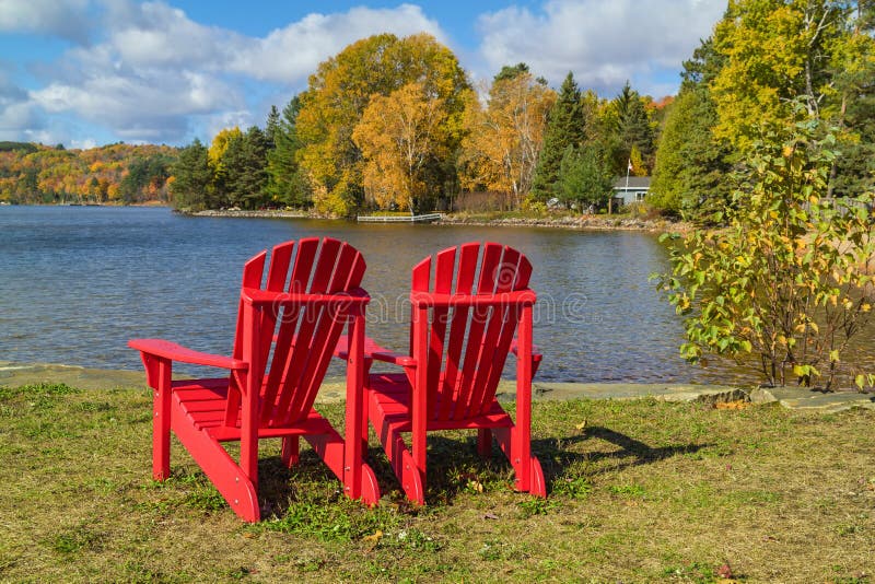Red Adirondack Chairs on a Lake Shore