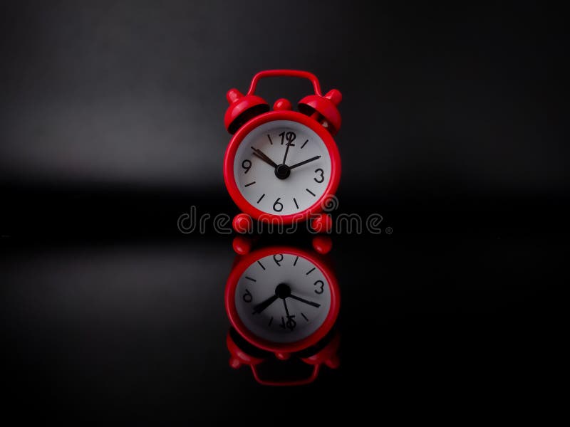 Red alarm clock on black background with reflection stock photos