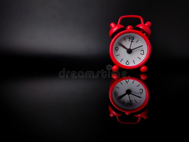 Red alarm clock on black background with reflection stock photos