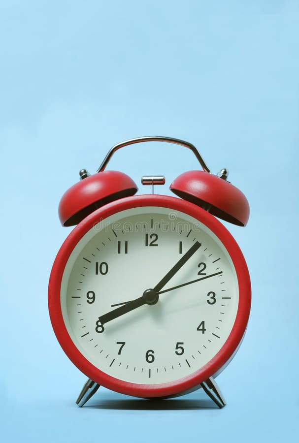 Red alarm clock on light blue color background. stock photo Red alarm clock on light blue color background. stock photo