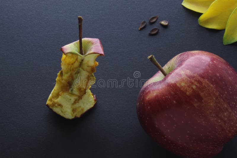 Red Apple and Apple Stump Stub Core Composition On Black Craft Paper Background.
