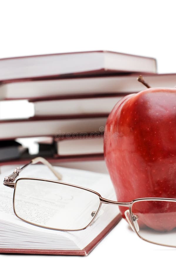 Red apple and glasses on the book