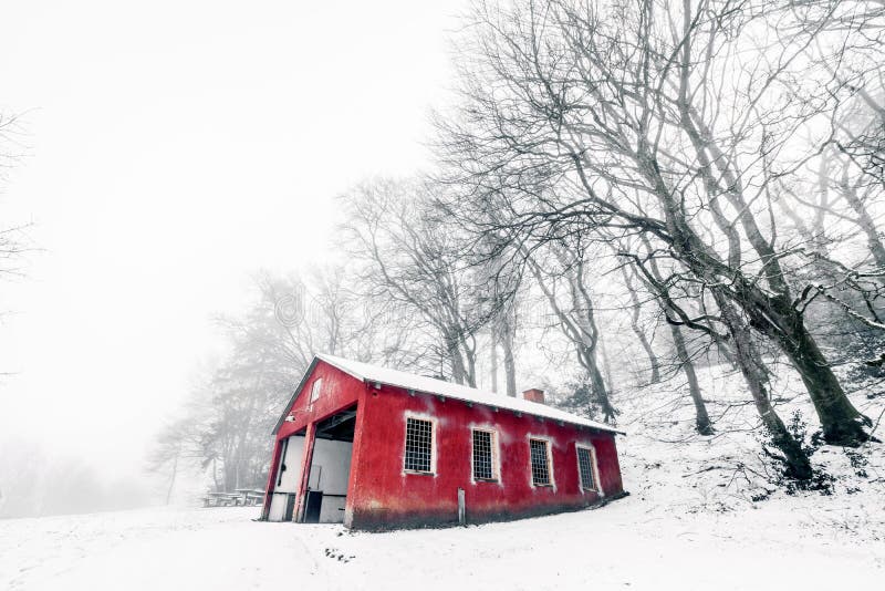 Red barn in a misty winter landscape.
