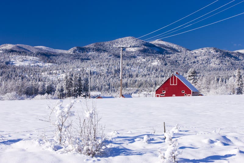 Red barn in snowy field.