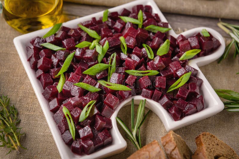 Red beet salad with onion and olive oil. next to the table lie a fork