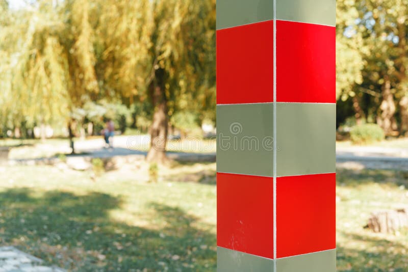 Red and beige striped milepost column on road