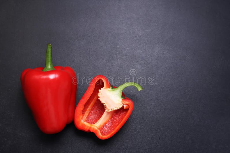 Red bell pepper paprika. Vegetables on a black textured background