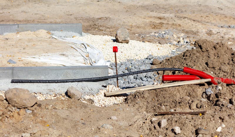 A red and black electrical cable is laying on the ground stock photo