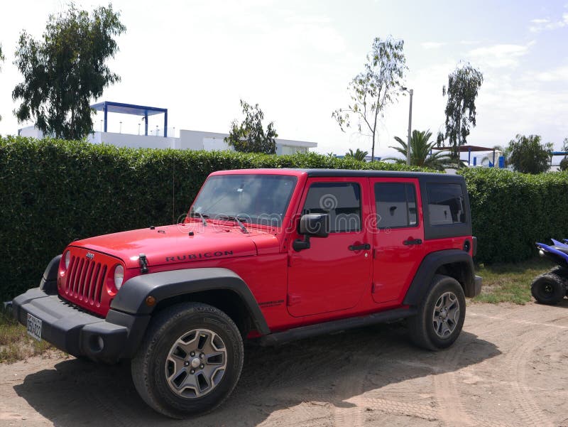  Jeep Wrangler rojo y negro estacionado en una playa de Lima Imagen editorial