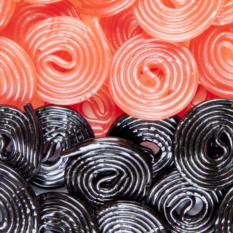 Red Licorice Wheel on a Background of Black Licorices Stock Photo