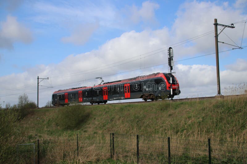 A red black train type Flirt of NS Albellio on the track in Gouda heading Alphen aan den Rijn royalty free stock image A red black train type Flirt of NS Albellio on the track in Gouda heading Alphen aan den Rijn royalty free stock image