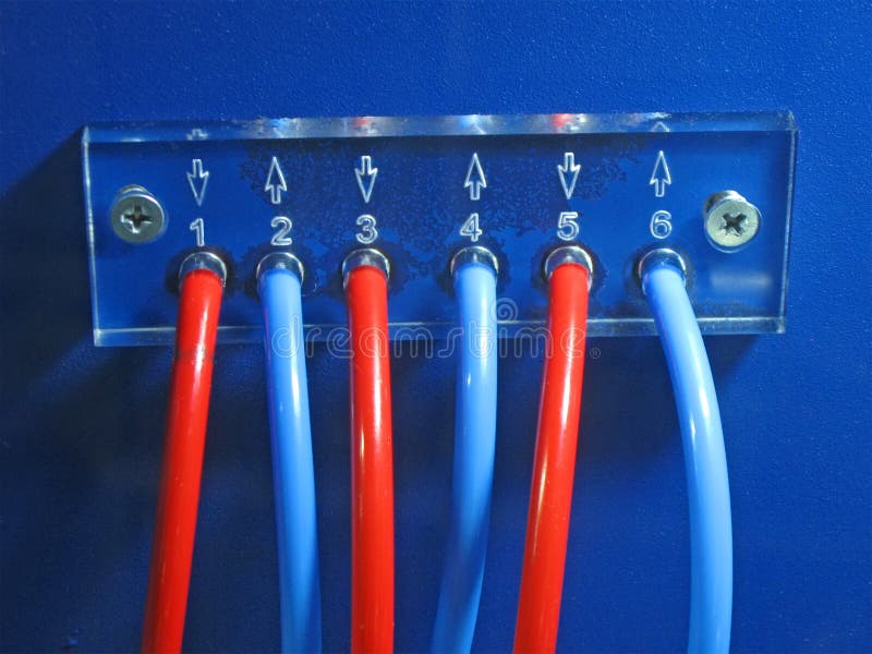 Red, blue connected cables pack on blue control panel surface fixed with few screw closeup. color power electricity, plexiglass royalty free stock photography
