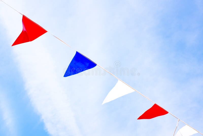 Red, blue and white flags against a blue sky stock image