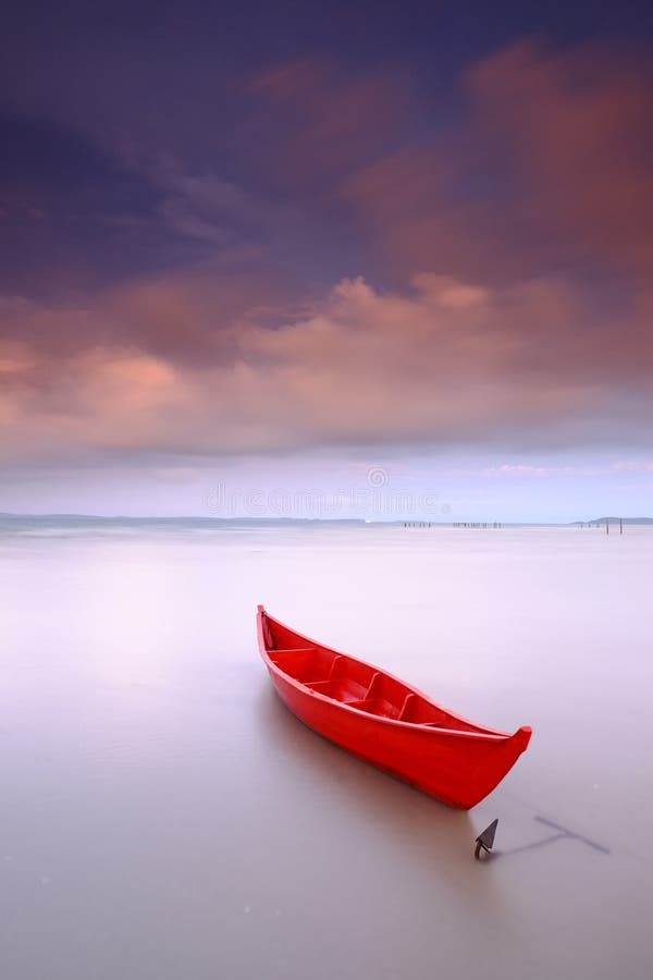 Red boat isolated anchored sunset